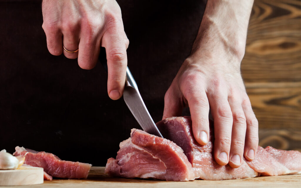 image of butcher cutting pork